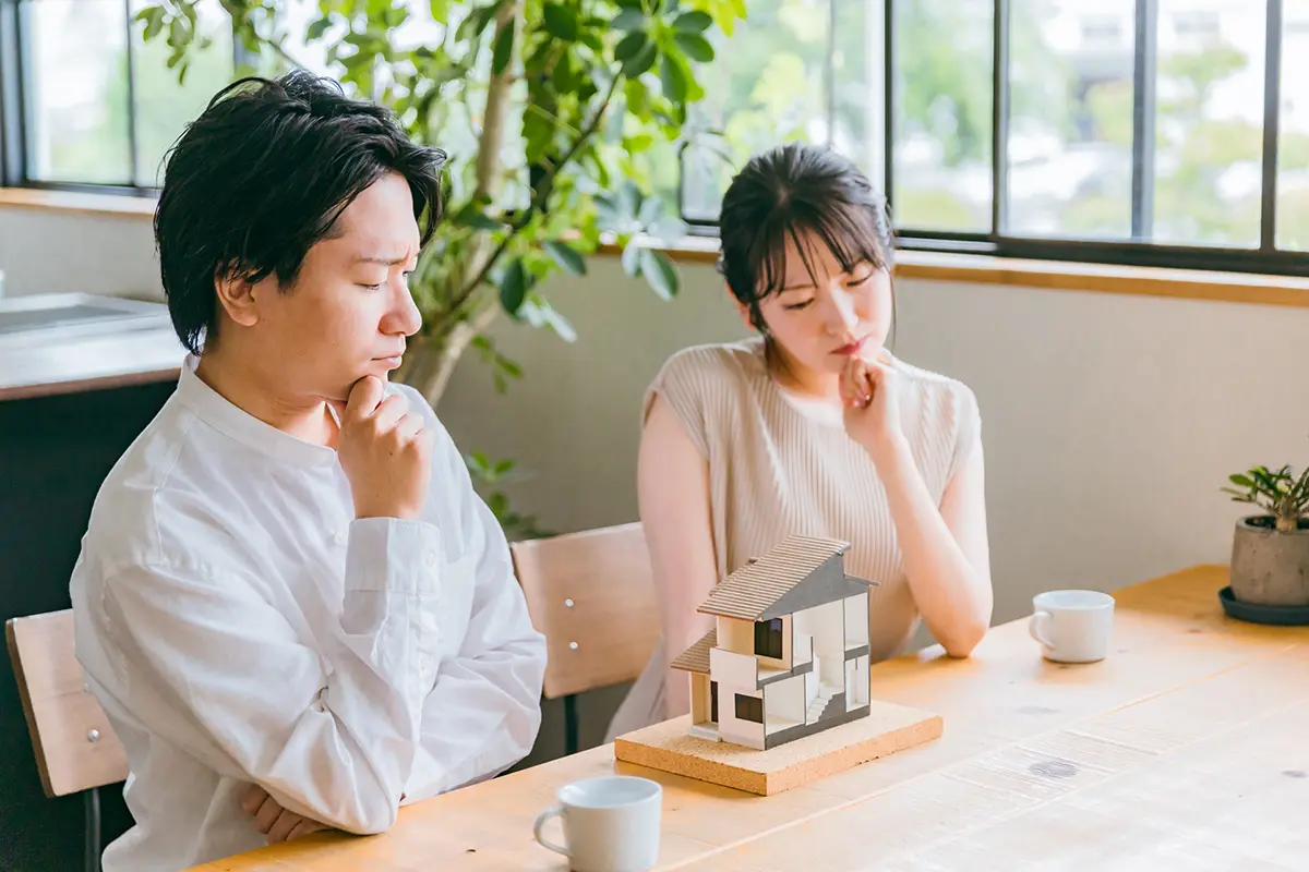 Dummy image: A couple seriously discussing home building plans, looking worried