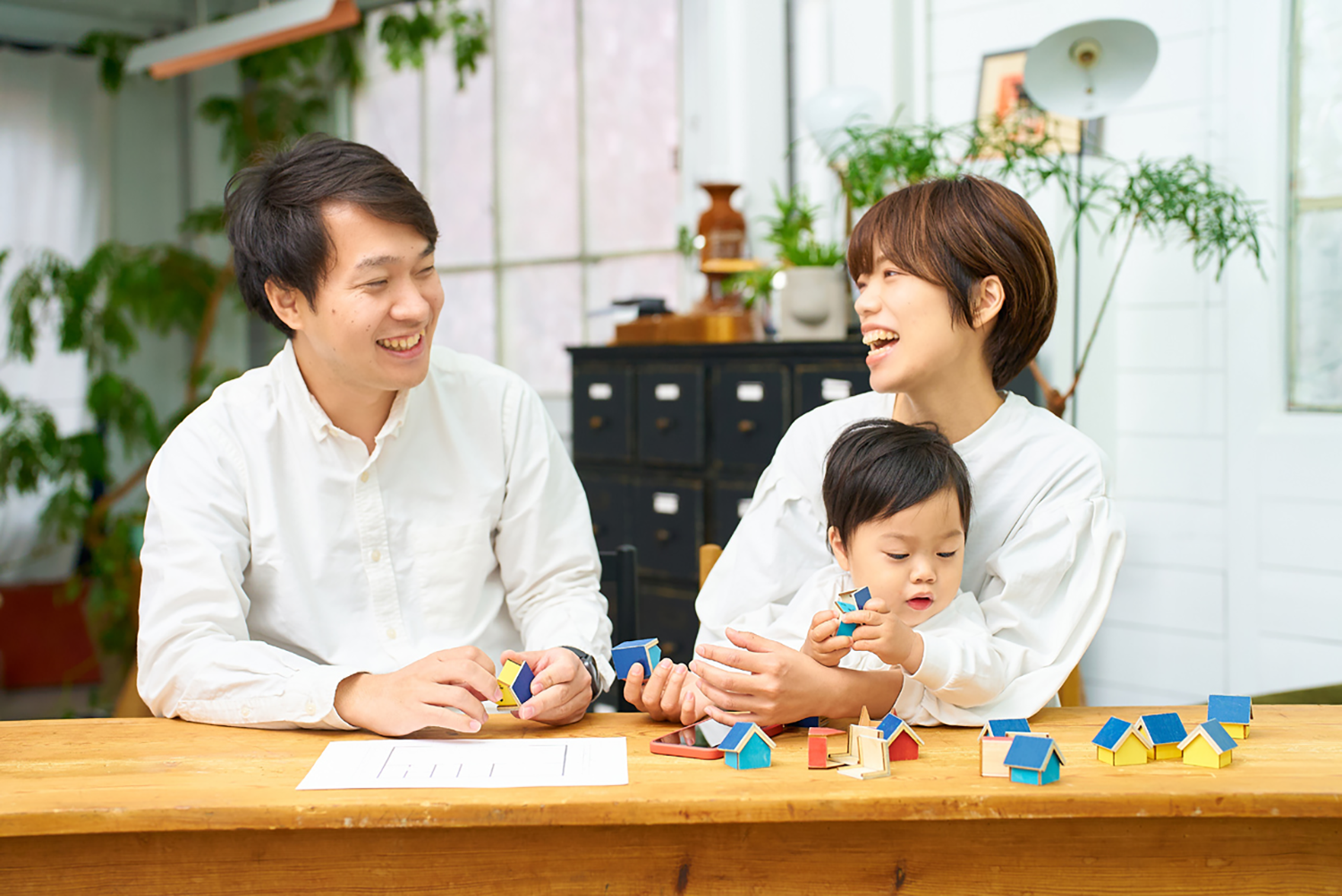 Dummy image: A family checking a clock and floor plan while planning their model house visit schedule